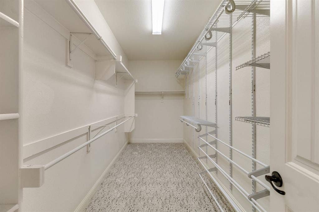1049 Mesa Crest Drive, Fort Worth, TX 76052 Spacious Primary walk-in closet featuring built-in shelving, hanging rods, and adjustable wire rack storage system