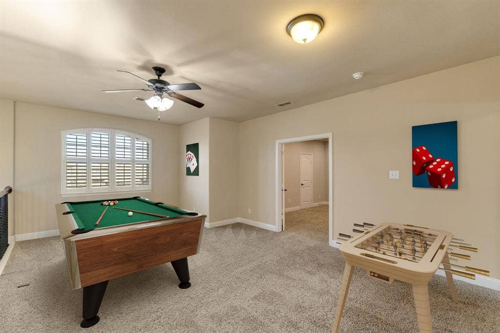 1049 Mesa Crest Drive, Fort Worth, TX 76052 Spacious bonus room featuring carpet flooring, an arched window with plantation shutters, a ceiling fan with integrated lighting, and neutral wall tones