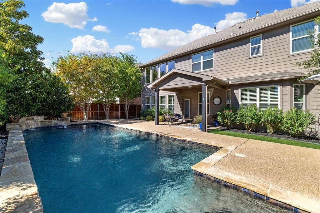 1049 Mesa Crest Drive, Fort Worth, TX 76052 Expansive backyard featuring a rectangular swimming pool, integrated spa with water feature, covered patio, and mature landscaping