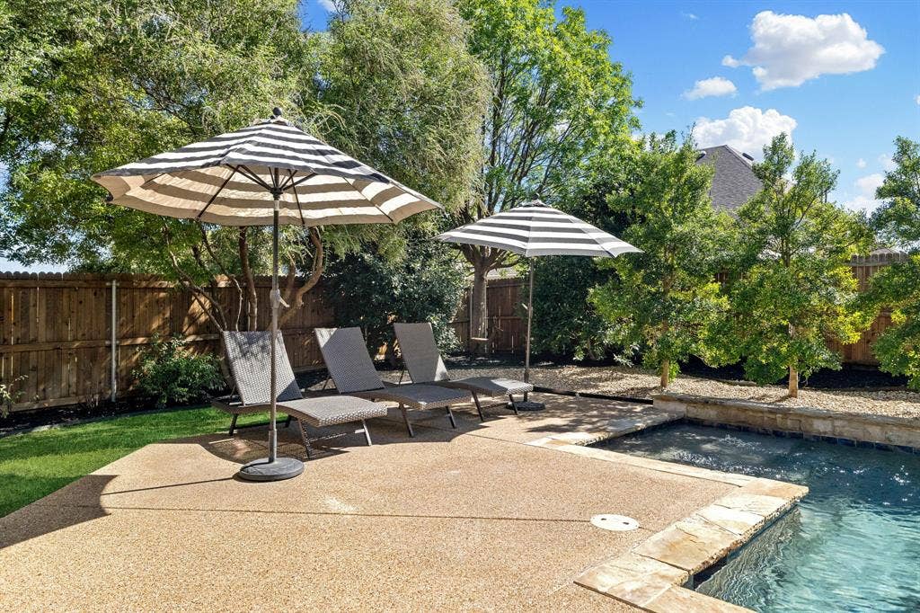 1049 Mesa Crest Drive, Fort Worth, TX 76052 Outdoor space featuring a swimming pool, stone coping, aggregate concrete decking, and a wood privacy fence