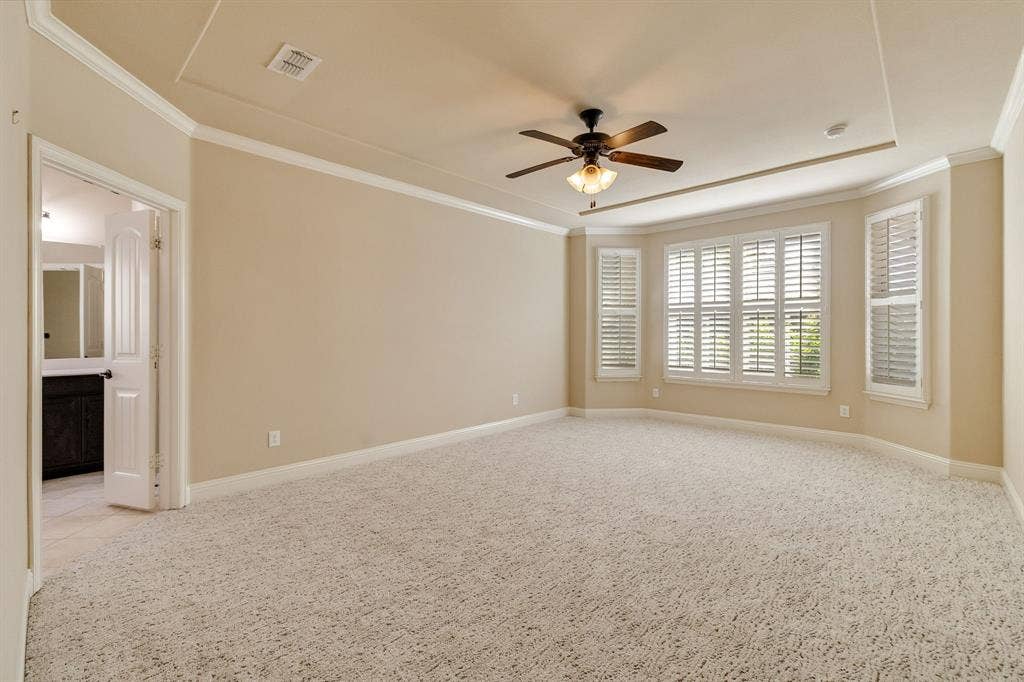 1049 Mesa Crest Drive, Fort Worth, TX 76052 Recessed ceiling with crown molding, ceiling fan with integrated lighting, bay window with plantation shutters, and plush carpeting