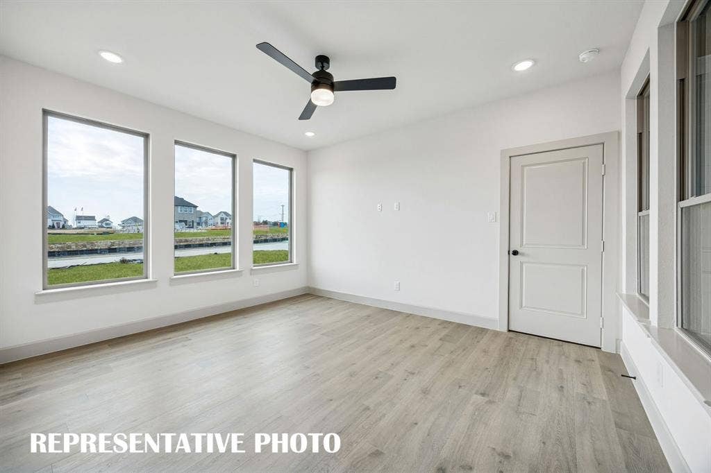 3729 Homer Court, McKinney, TX 75071 A wall of windows floods this family room with natural light creating a bright and inviting space. REPRESENTATIVE PHOTO