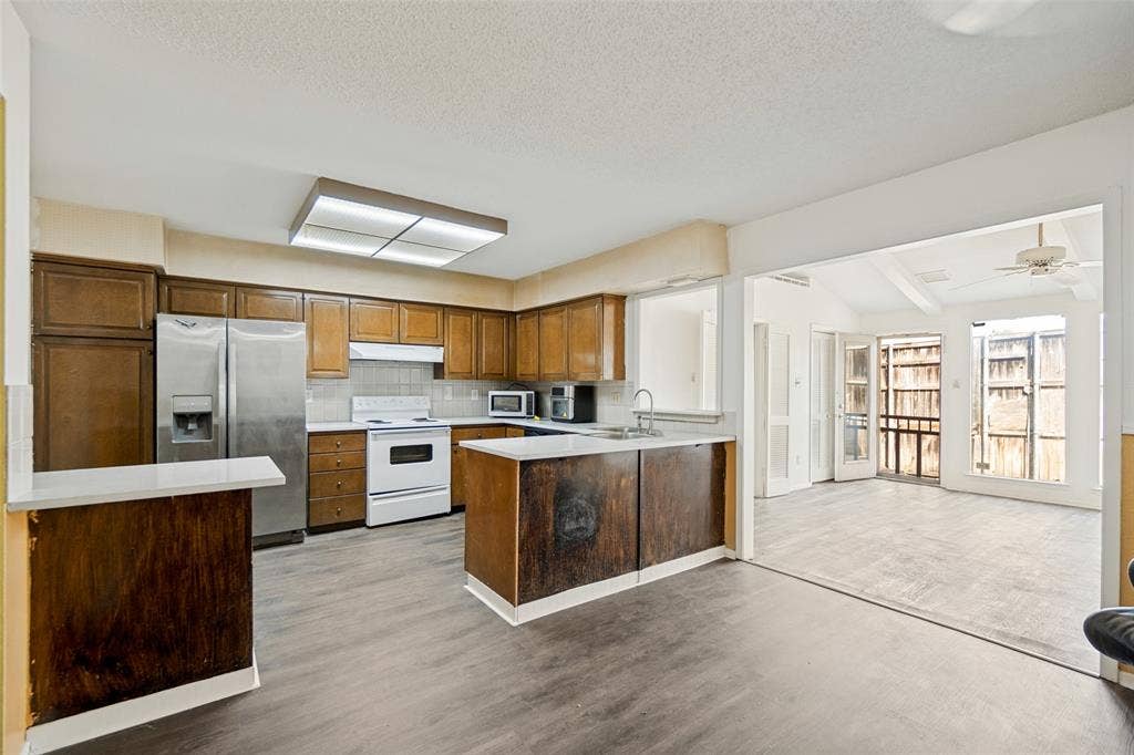 11916 Leisure Drive, Dallas, TX 75243 Kitchen featuring wood-finish cabinetry, stainless steel refrigerator, white electric range, and wood-finish flooring