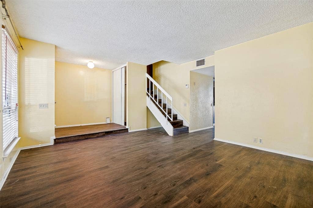 11916 Leisure Drive, Dallas, TX 75243 Wood-finish flooring, staircase with white railing, built-in storage closet, and ceiling-mounted light fixture