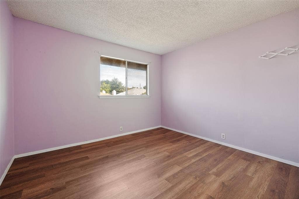 11916 Leisure Drive, Dallas, TX 75243 Wood-finish flooring, single window, and light-colored walls