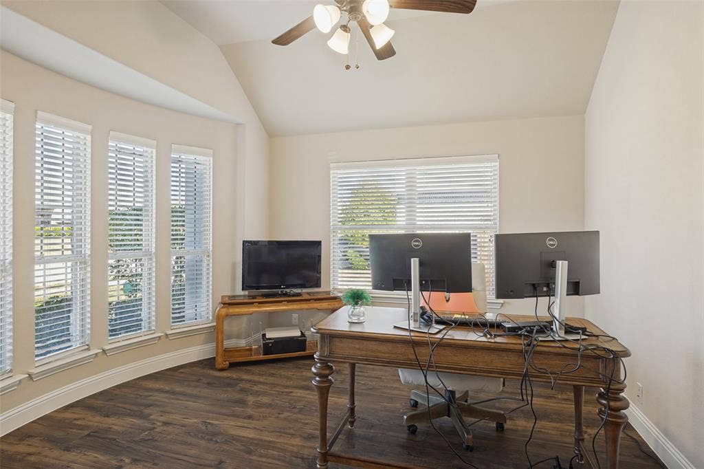 View of office off foyer.  Office has French Doors, large bay window, ceiling fan, and laminate flooring.