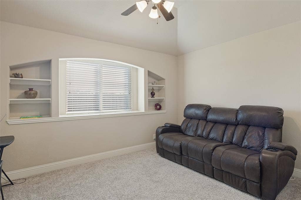 Secondary bedroom which has shelves and large window,