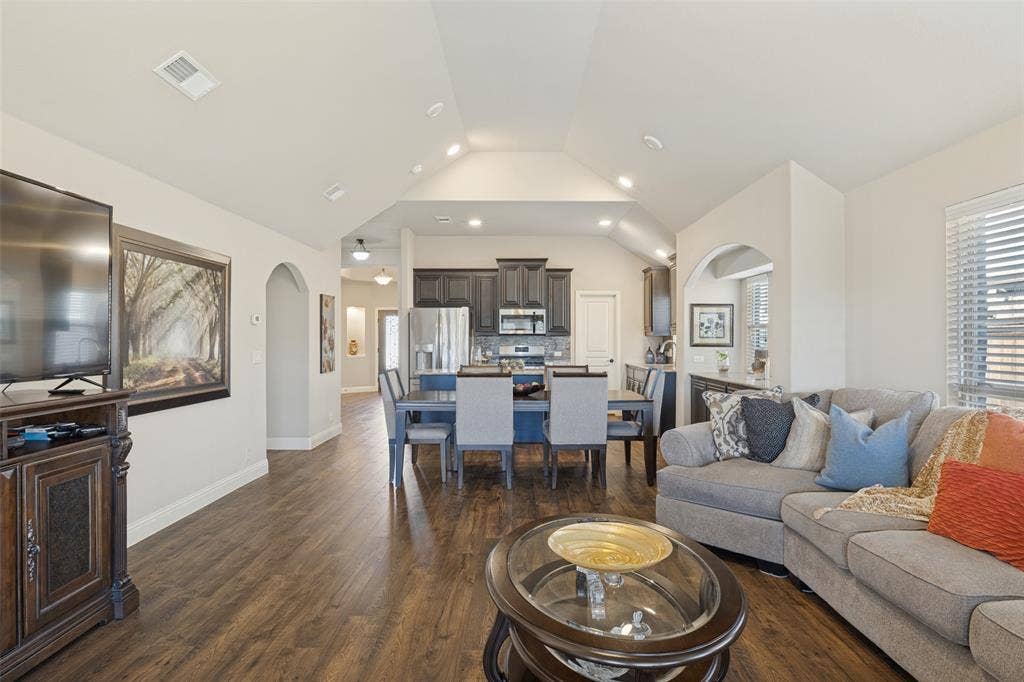 View from living area looking toward dining area and kitchen.  The home has arch entry way to bedrooms.