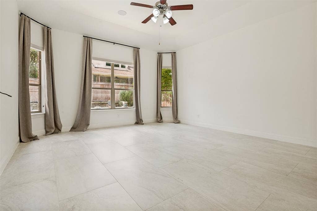6734 Trailblazer Way, Dallas, TX 75236 Spacious room featuring light-toned tile flooring, multiple windows, a ceiling fan with integrated lighting, and recessed ceiling speaker