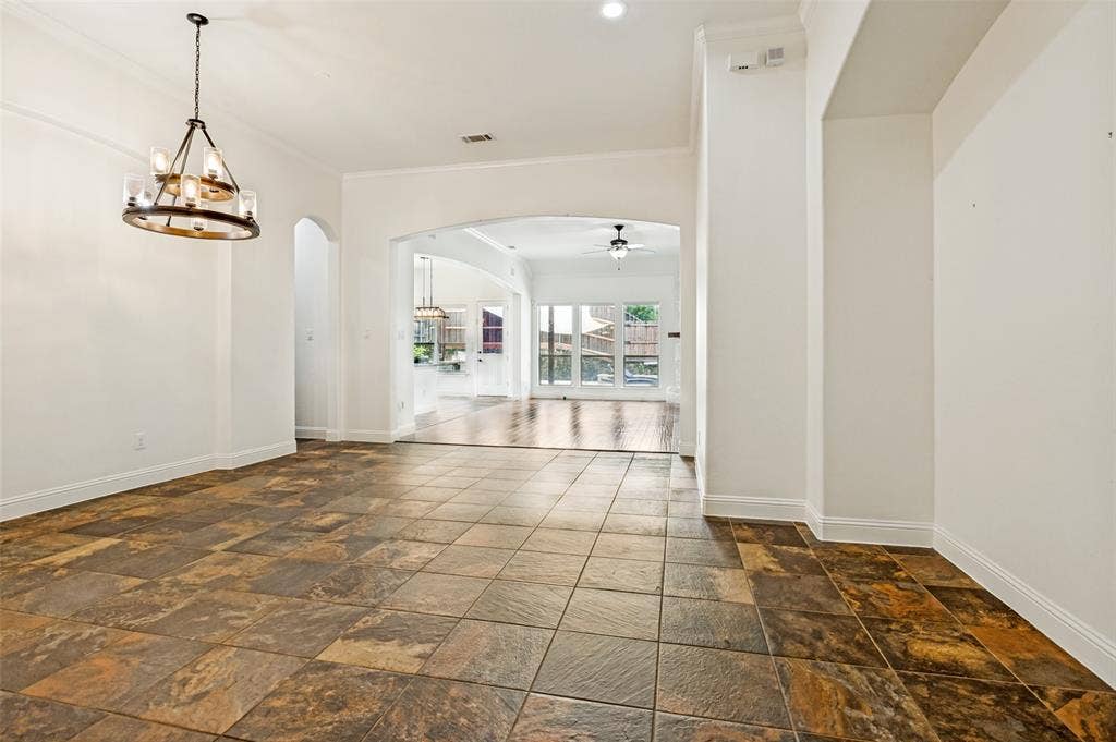 6734 Trailblazer Way, Dallas, TX 75236 Stone tile flooring with arched doorways and a decorative chandelier