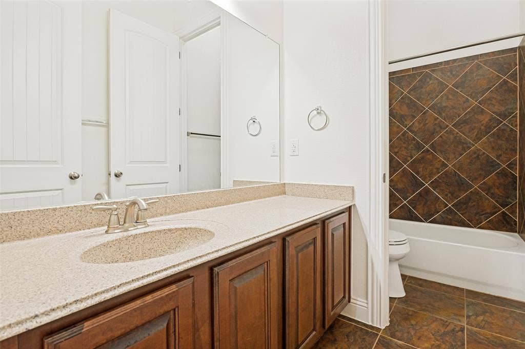 6734 Trailblazer Way, Dallas, TX 75236 Vanity with light-toned countertop, integrated sink, and wood-finish cabinetry