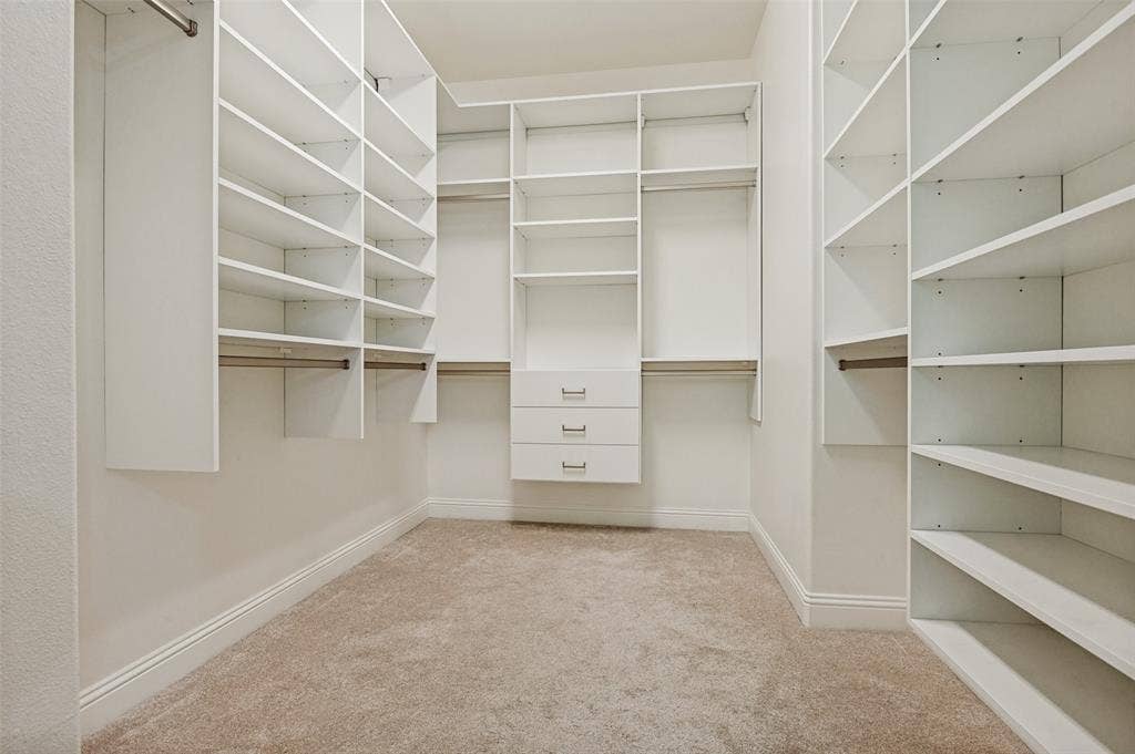 6734 Trailblazer Way, Dallas, TX 75236 Walk-in closet featuring extensive built-in shelving, multiple hanging rods, and integrated drawers