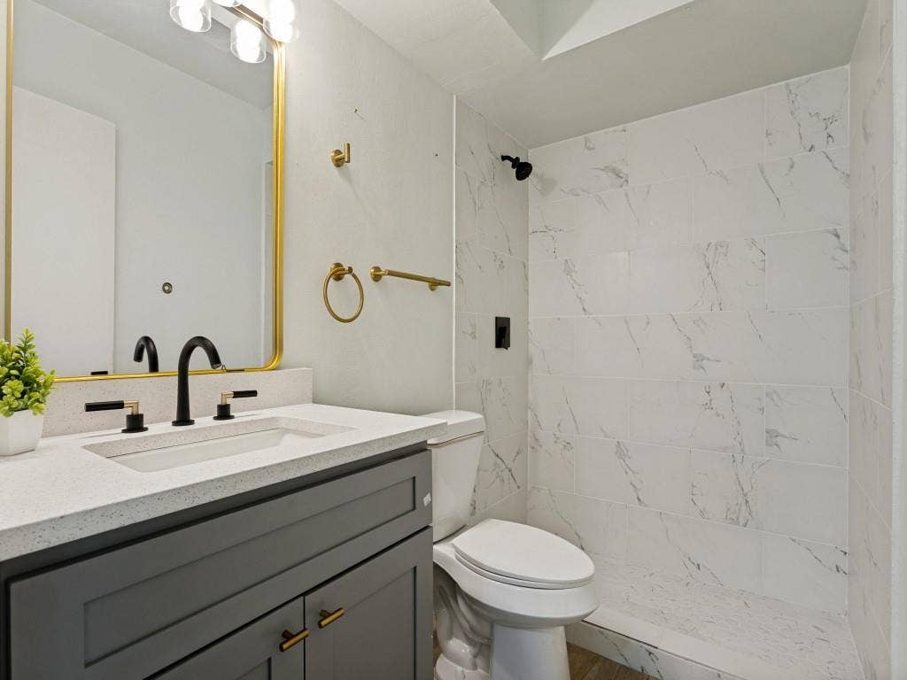 2018 Vail Drive, Garland, TX 75044 Vanity with a light-colored countertop, integrated sink, and dark cabinetry