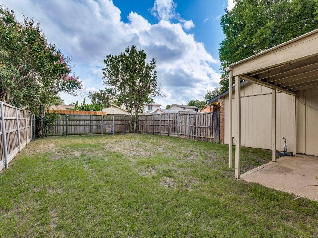 2018 Vail Drive, Garland, TX 75044 Expansive fenced backyard featuring a covered patio with a concrete surface