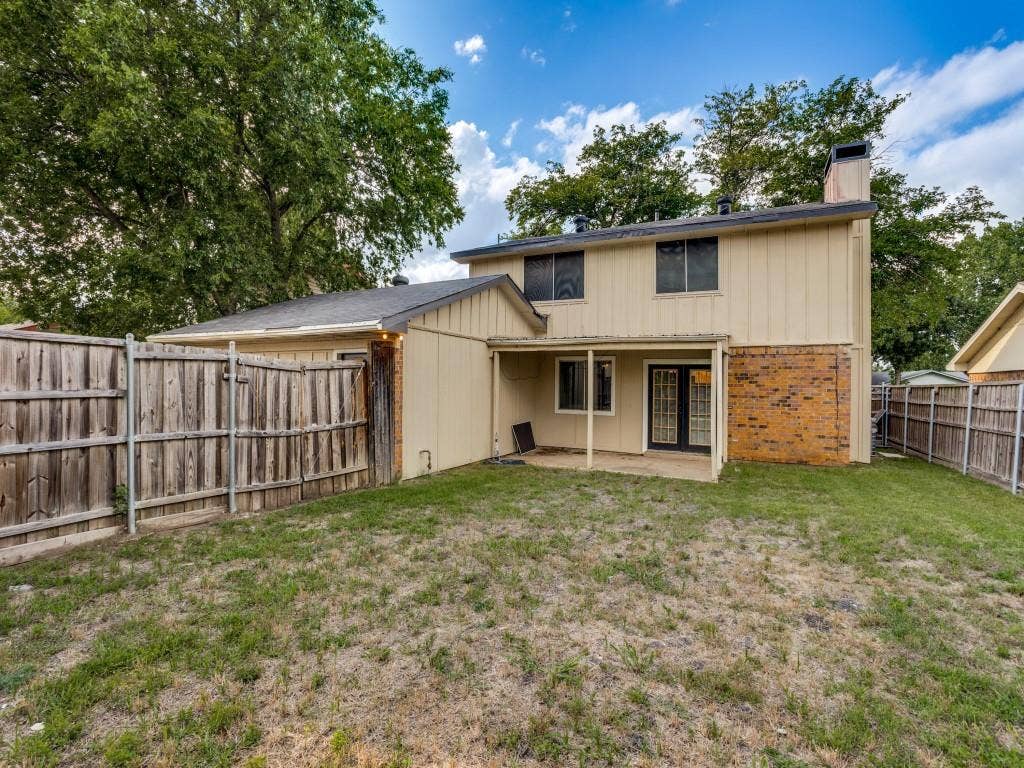 2018 Vail Drive, Garland, TX 75044 Rear exterior with a covered patio, brick and siding facade, and fenced yard