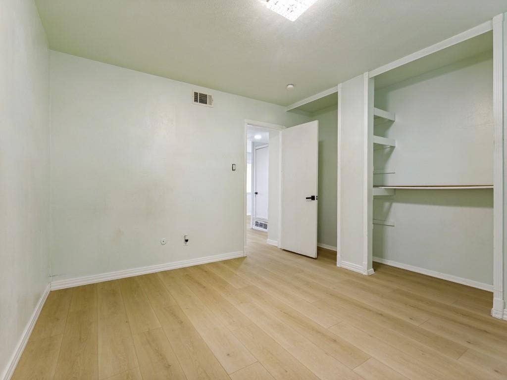 2018 Vail Drive, Garland, TX 75044 Wood-finish flooring, built-in shelving, white trim, and a ceiling-mounted light fixture