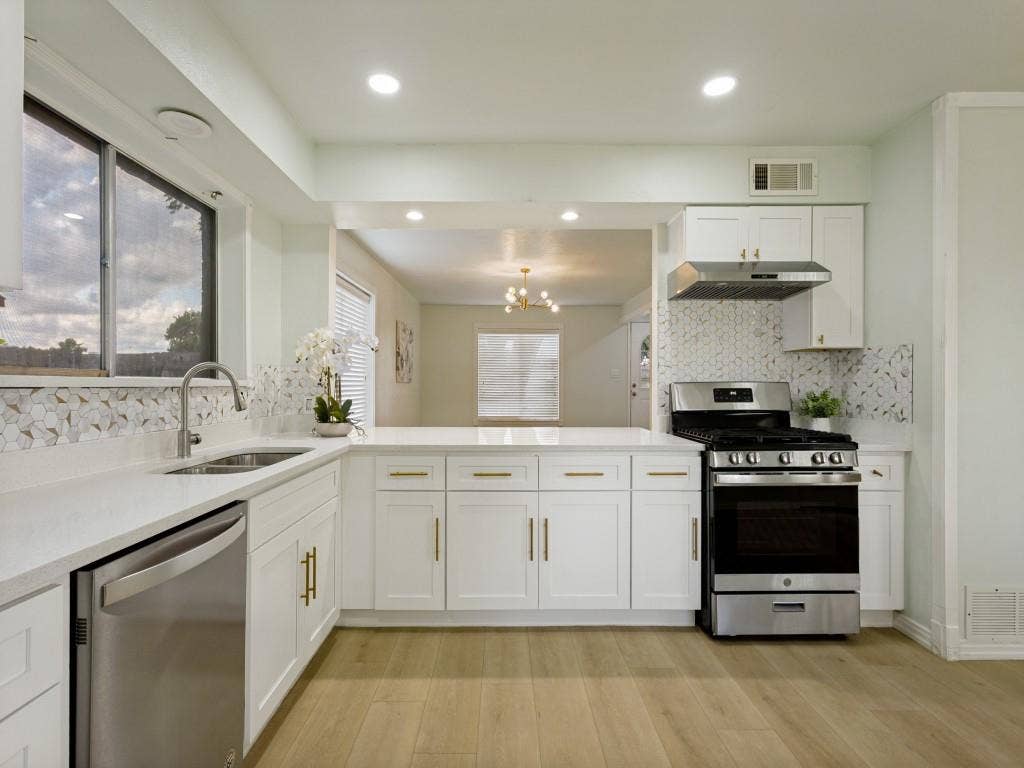 2018 Vail Drive, Garland, TX 75044 White cabinetry with gold-tone hardware, white countertops, stainless steel appliances, and a mosaic tile backsplash
