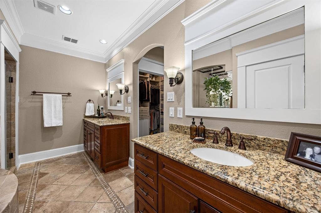 Primary bathroom with dual, separate vanities.