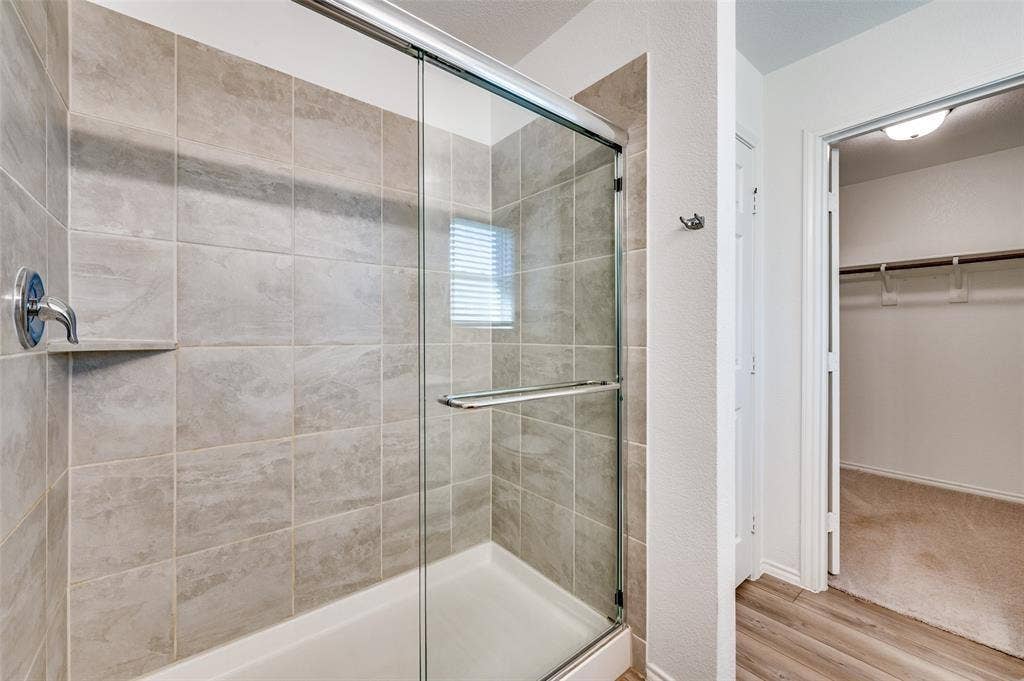 845 Poppy Cove Lane, Princeton, TX 75407 Glass-enclosed shower with subway-tiled walls and an integrated shower niche