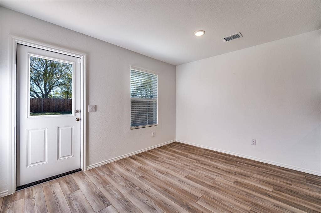 845 Poppy Cove Lane, Princeton, TX 75407 Wood-finish flooring, white walls, recessed lighting, and a window with blinds provide a bright and neutral interior