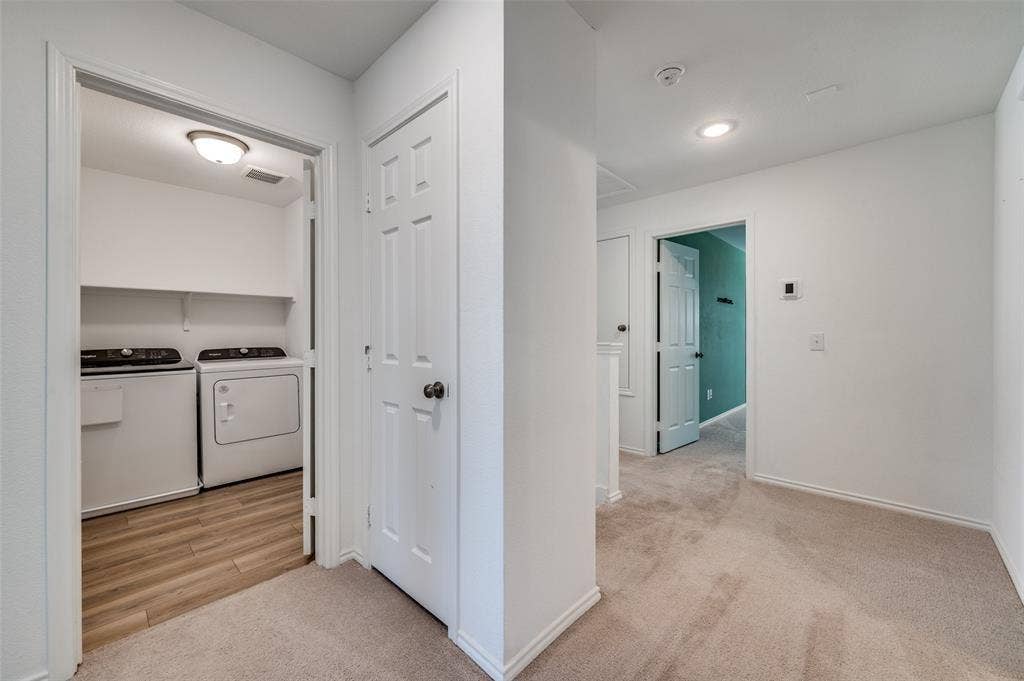 845 Poppy Cove Lane, Princeton, TX 75407 Laundry space with wood-finish flooring, two upper shelves, and an overhead light fixture