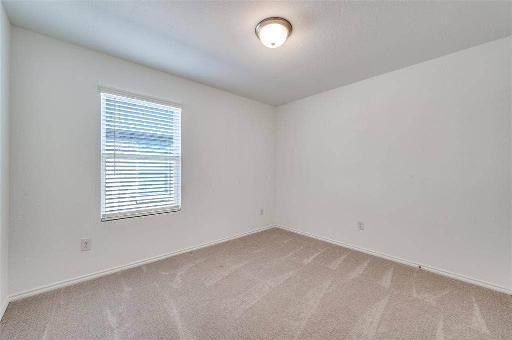 845 Poppy Cove Lane, Princeton, TX 75407 Neutral-toned walls, carpeted flooring, and a single window with horizontal blinds
