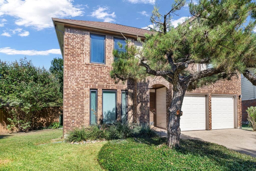 765 Eiffel Drive, Plano, TX 75023 Brick facade with a two-car garage, arched entry, and established landscaping