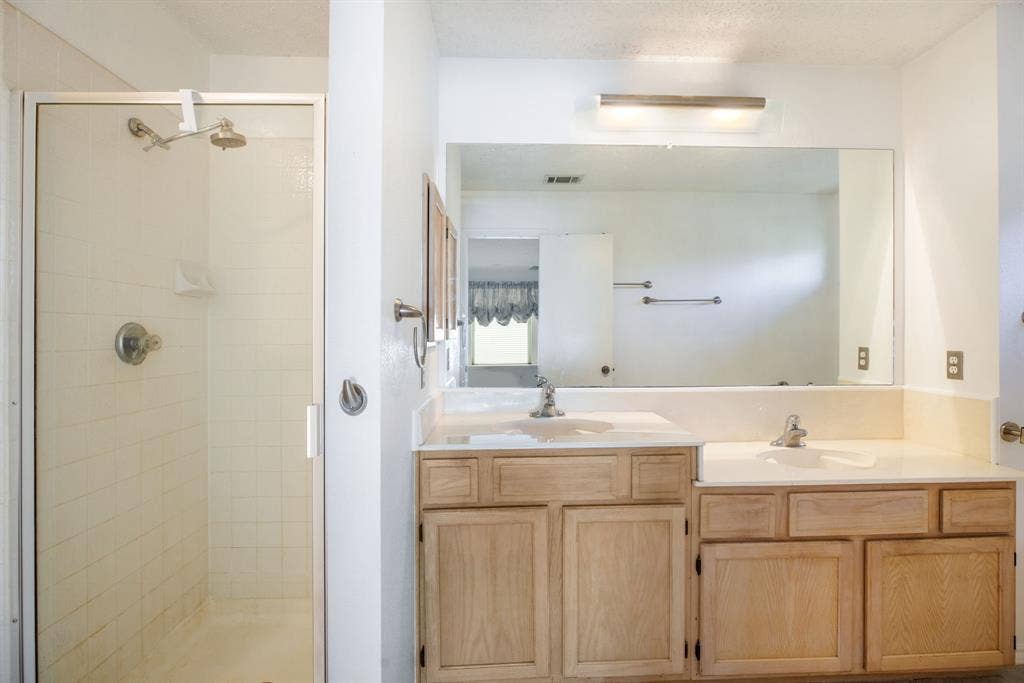 765 Eiffel Drive, Plano, TX 75023 Shower with glass enclosure, dual vanity with integrated sinks, and neutral countertops