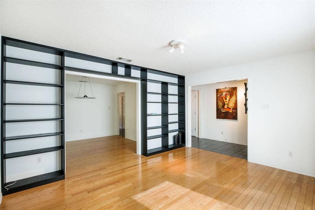 765 Eiffel Drive, Plano, TX 75023 Hardwood flooring, recessed lighting, and built-in shelving with an open archway