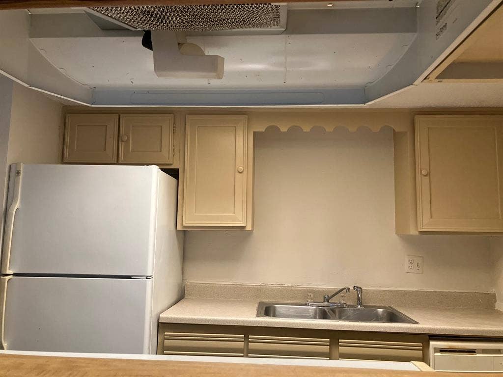5727 Harvest Hill Road, #1042, Dallas, TX 75230 Dual basin stainless steel sink with chrome faucet, light-toned countertop, and integrated refrigerator