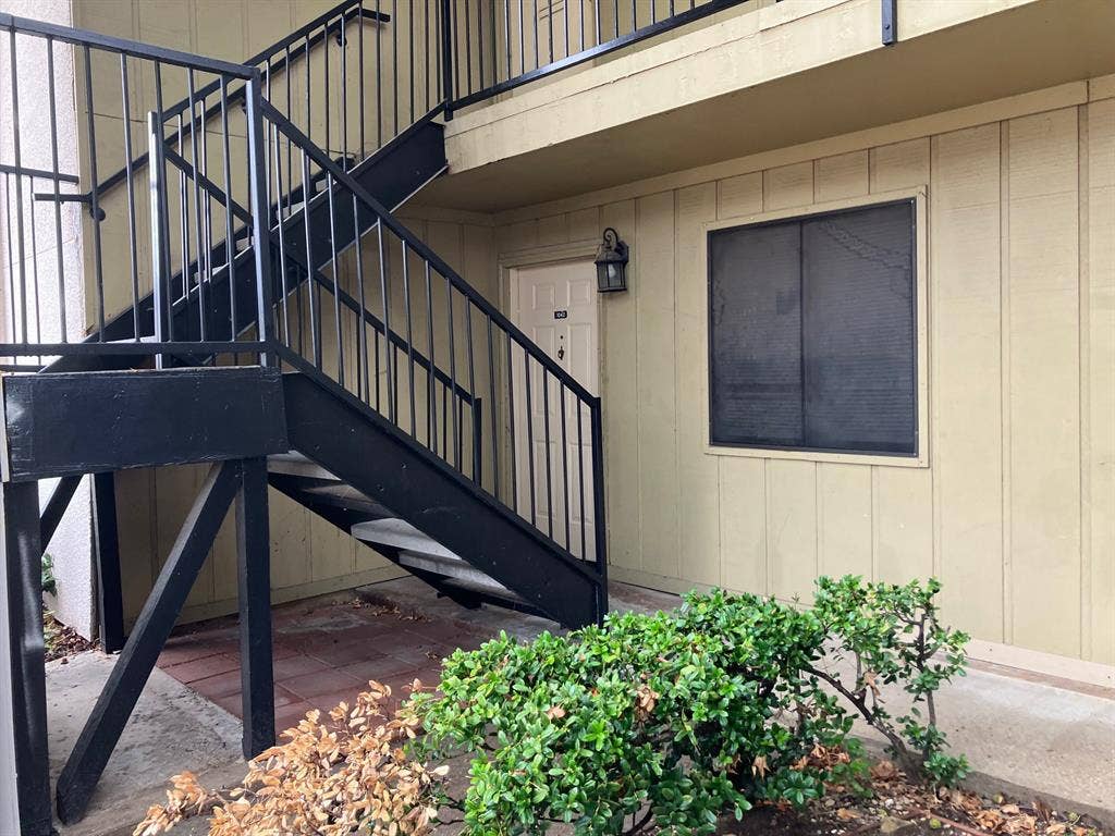 5727 Harvest Hill Road, #1042, Dallas, TX 75230 Exterior featuring vertical siding and a black metal staircase