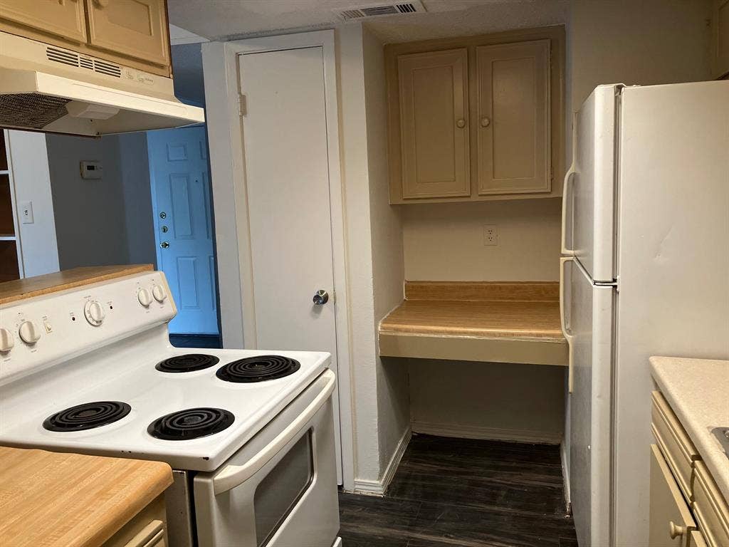 5727 Harvest Hill Road, #1042, Dallas, TX 75230 Compact kitchen featuring a white electric range, wood-finish countertops, and matching cabinetry