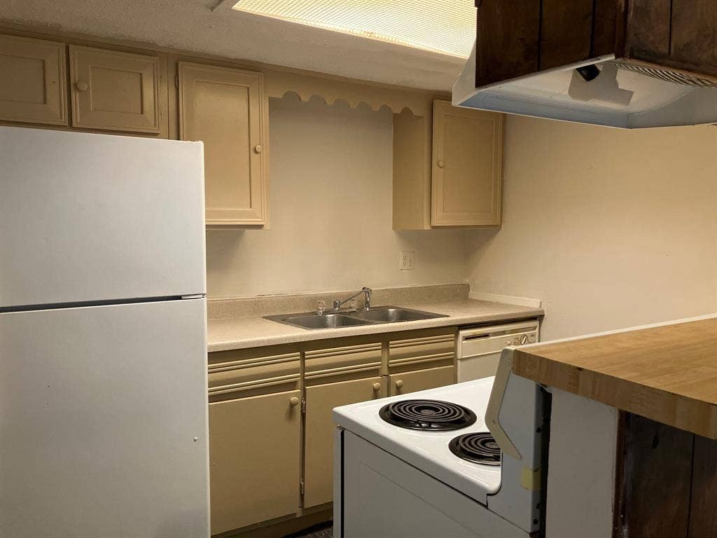 5727 Harvest Hill Road, #1042, Dallas, TX 75230 Kitchen featuring wood-finish cabinetry, a double basin stainless steel sink, a dishwasher, a white electric range, and a white refrigerator