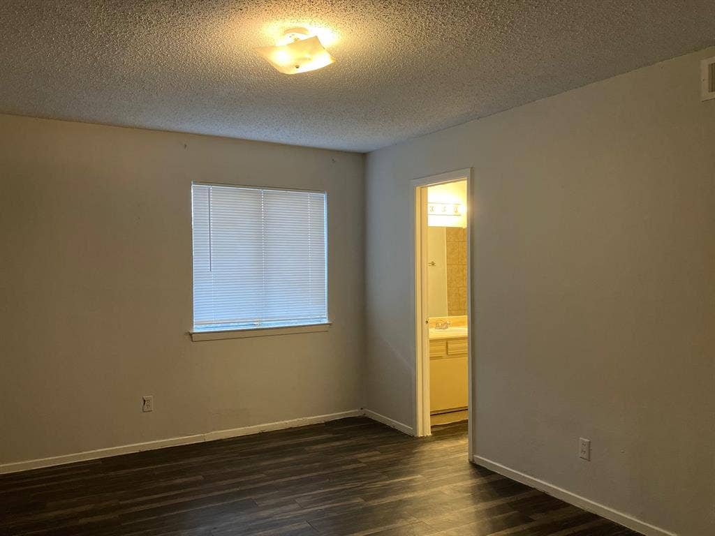 5727 Harvest Hill Road, #1042, Dallas, TX 75230 Wood-finish flooring throughout, bright window with blinds, and a built-in ceiling light fixture