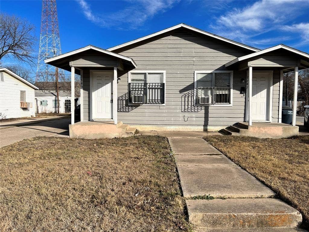 2745 S Jones Street, Fort Worth, TX 76104 Exterior featuring gray siding, covered entryways, and security bars on windows