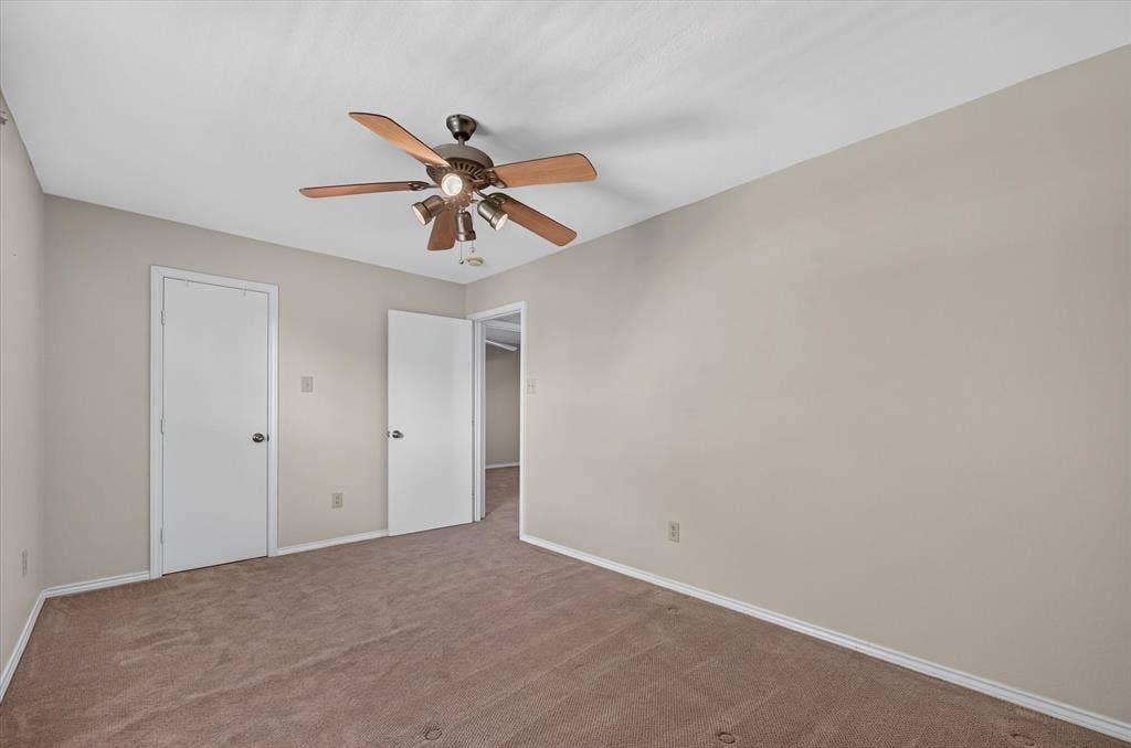 One of two upstairs bedrooms that has a ceiling fan, a walk in closet and upgraded carpet.