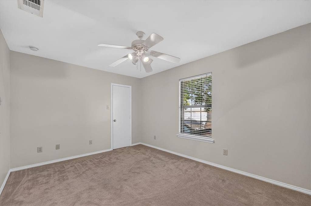 One of two secondary upstairs bedrooms with a ceiling fan, walk in closet and upgraded carpet.