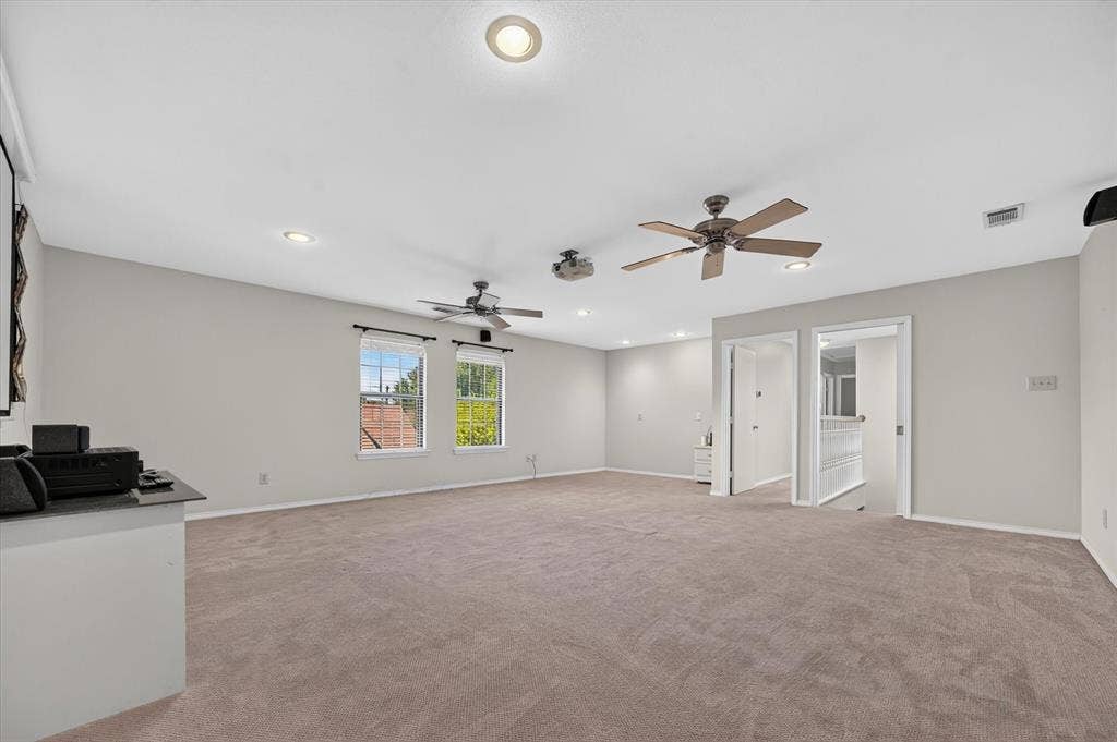 The large upstairs game room has a pocket door at the top of the stairs, 2 fans, projector & screen that will convey with the house. This room is big enough to have set up as a media room and you still have room for game tables.
