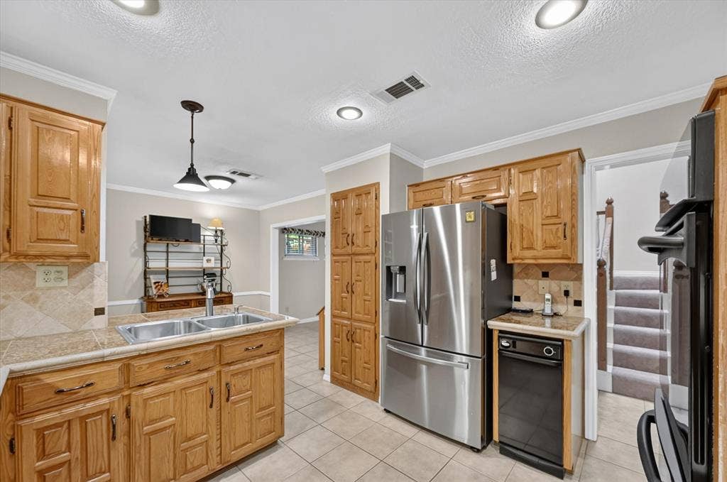 The kitchen has a deep double stainless sink, lots of cabinets, trash compactor & looks into the breakfast area.