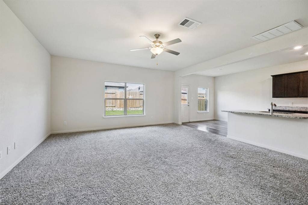Spacious room with gray carpet flooring and white walls