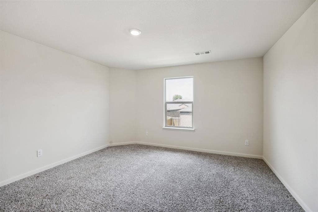 Recessed ceiling lighting, light gray wall paint, gray patterned carpeting, double-pane window, and white trim
