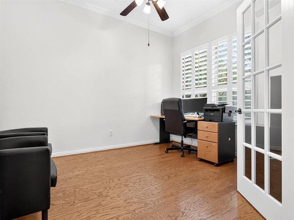 French doors with divided lites, wood-finish flooring, plantation shutters, and a ceiling fan