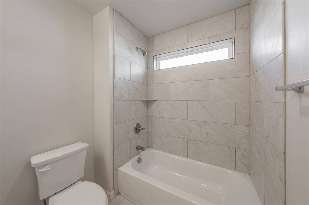 6215 Roby Drive, Arlington, TX 76001 Bathroom featuring tiled shower / bath combo and toilet