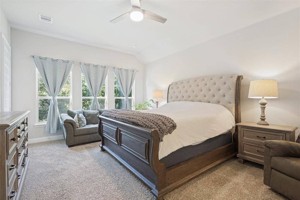 Vaulted ceiling with a ceiling fan, three large windows, and wall-to-wall carpeting
