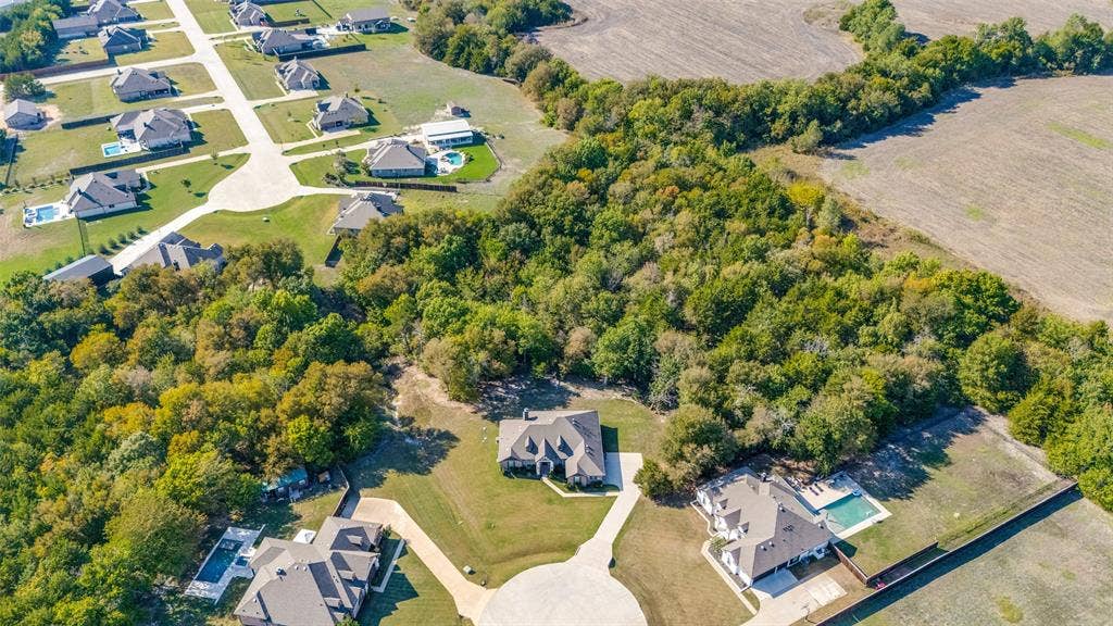 Expansive residential development with mature trees, established properties, and paved roadways