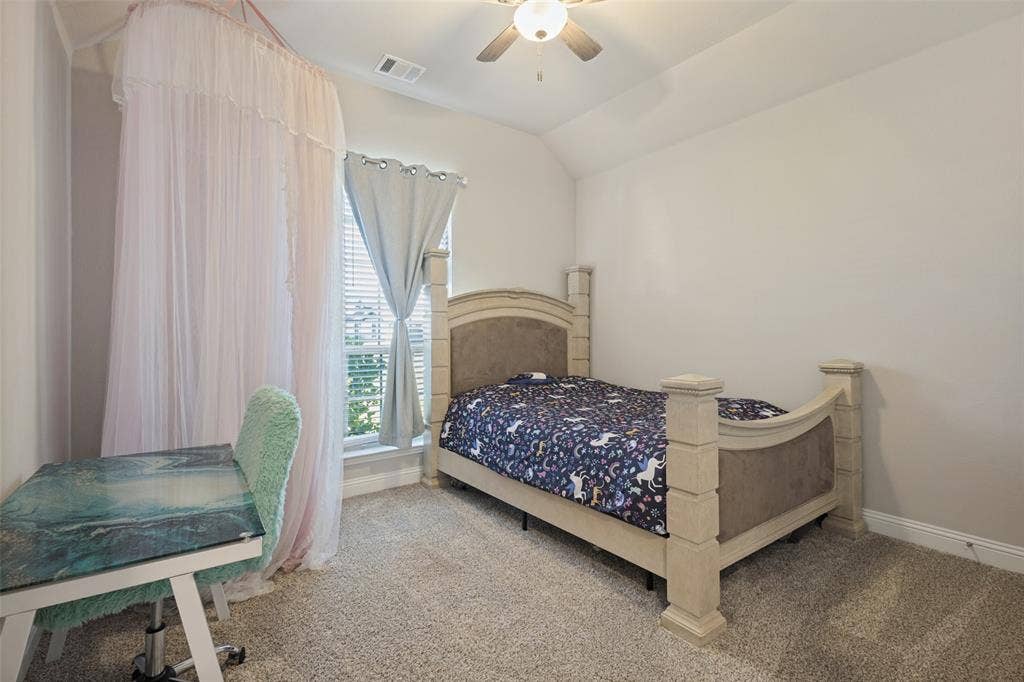 Carpeted room with a vaulted ceiling, a window featuring blinds, and a ceiling fan with integrated lighting