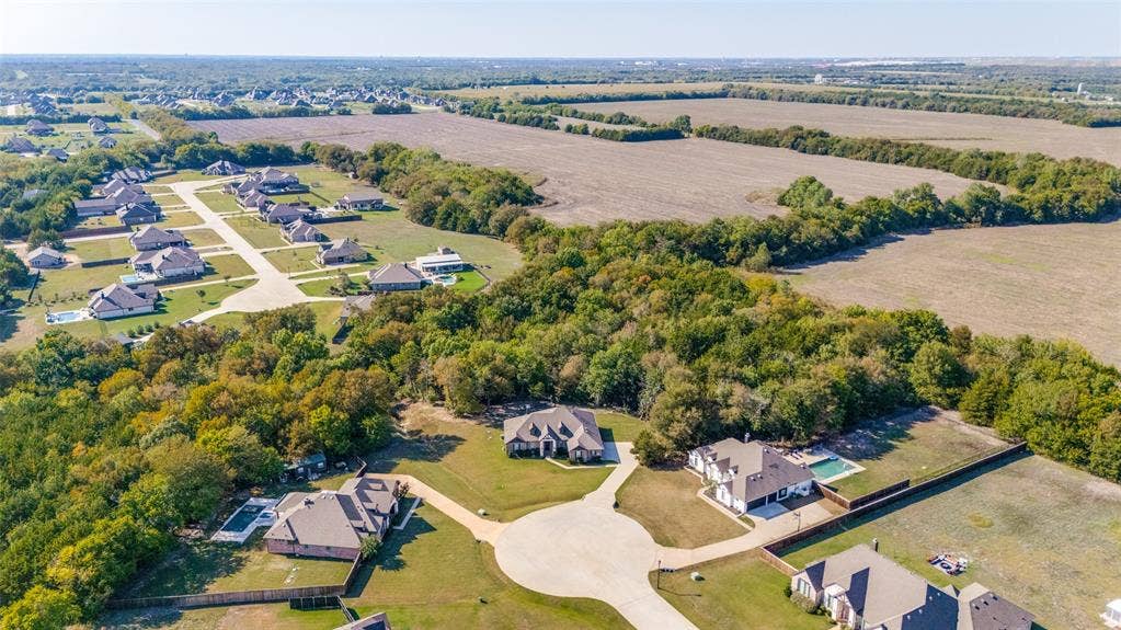 Residential development featuring numerous single-family residences, extensive green spaces, and a cul-de-sac