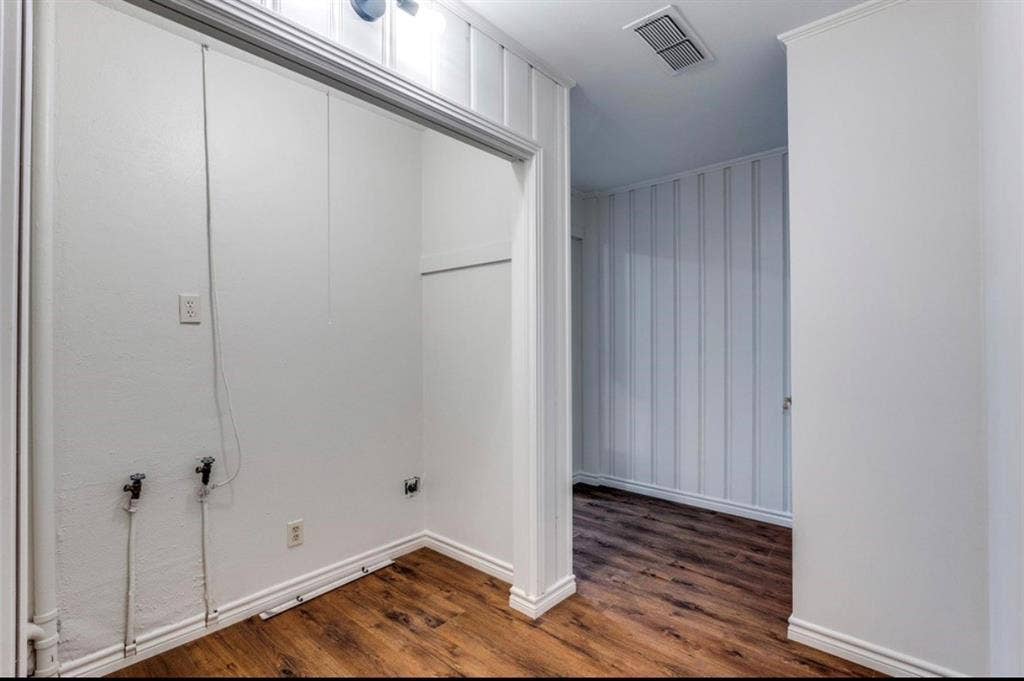 Utility area with wood-finish flooring and integrated washer/dryer connections