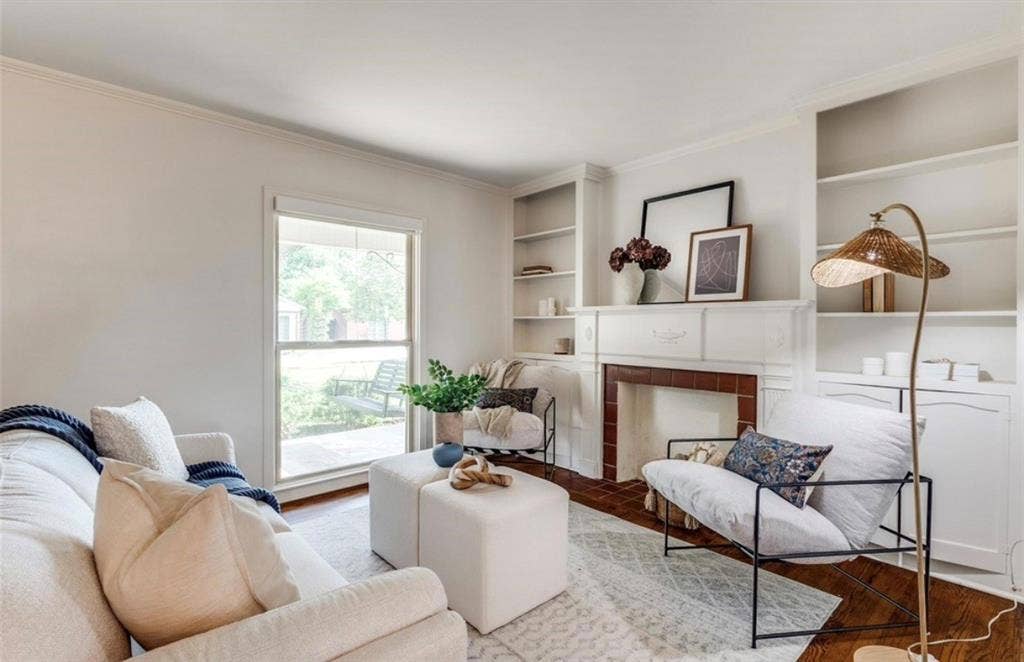 Fireplace with a mantel, built-in shelving, and wood-finish flooring.