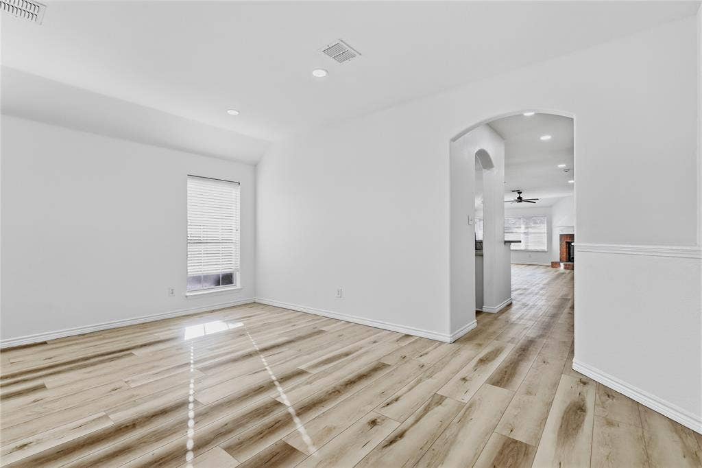 10709 Nantucket Drive, Rowlett, TX 75089 Light wood-finish flooring, recessed lighting, arched entryway, and a window with blinds